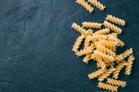 Raw uncooked pasta over dark backgroundの写真素材