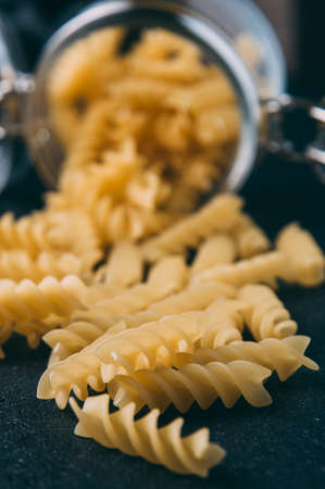 Raw uncooked pasta over dark backgroundの写真素材