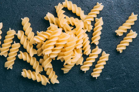 Raw uncooked pasta over dark backgroundの写真素材