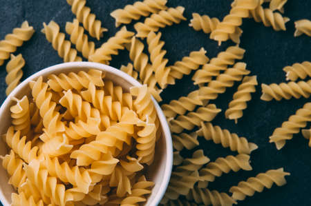 Raw uncooked pasta over dark backgroundの写真素材