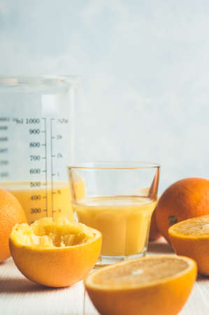 Citrus and orange juice in a glass on a light background
