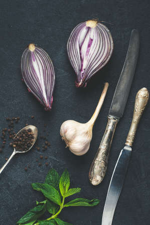 Onion, garlic, pepper and other spices on dark concrete backgroundの写真素材