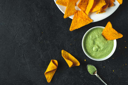 Mexican corn chips and fresh sauce on dark concrete backgroundの写真素材