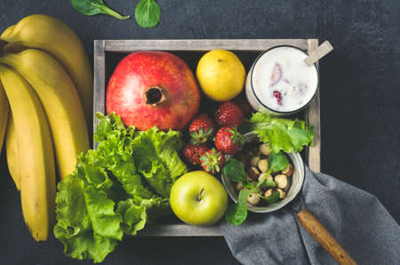 Fresh fruit and milkshake in a wooden box over dark concrete backgroundの写真素材