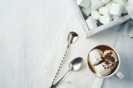 White coffee Cup and marshmallows in a wooden box over a white backgroundの写真素材