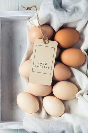 Chicken eggs in a white wooden box on a white backgroundの写真素材