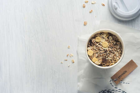 Breakfast cereals in paper cups over white wooden background. Diet or healthy eating conceptの写真素材