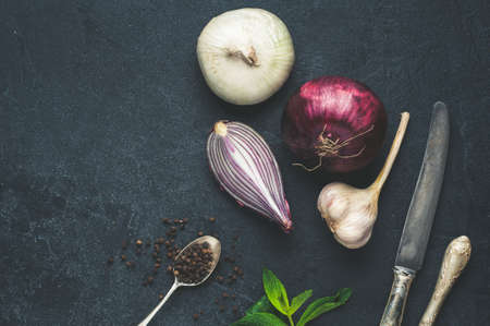 Onion, garlic, pepper and other spices on dark concrete backgroundの写真素材