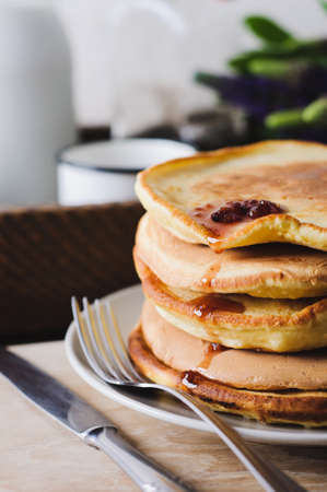Pancakes and jam on an old wooden table. A still life with lupines and wareの写真素材
