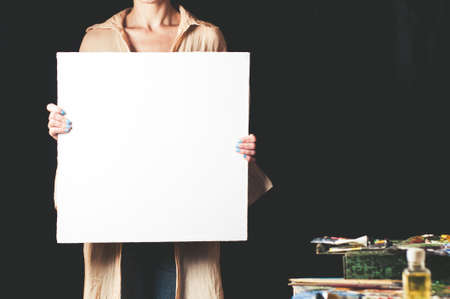 White canvas in the woman's hands. The place for the text or design on a canvasの写真素材