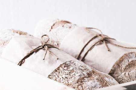 Homemade bread on a chopping board on a white concrete backgroundの写真素材