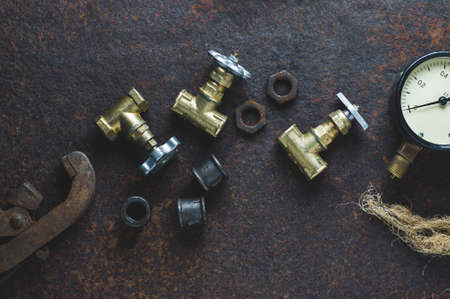Old wrenches and water gates on a rusty iron backgroundの写真素材