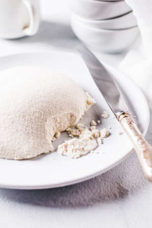 Fresh homemade cheese on a white concrete backgroundの写真素材