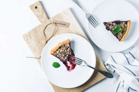 Portion of pie with jam on a white ceramic plate over a white concrete backgroundの写真素材