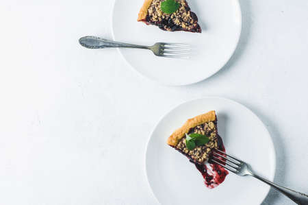 Portion of pie with jam on a white ceramic plate over a white concrete backgroundの写真素材