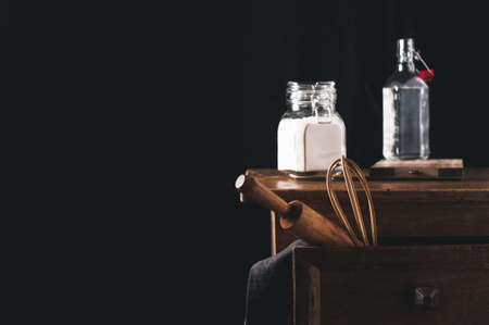 Kitchen table with ingredients for cooking on a black backgroundの写真素材
