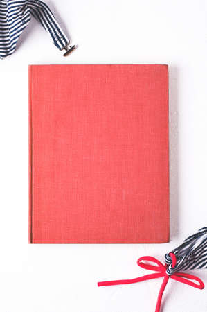 Retro style striped swimsuit and pink book cover on a white concrete backgroundの写真素材