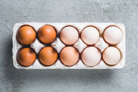 Chicken eggs in a box on a grey concrete backgroundの写真素材