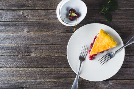 Cherry pie and fresh berries in a bowl on a dark wooden tableの写真素材
