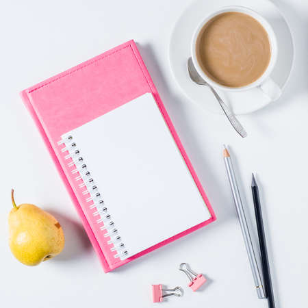 Notebook, coffee and office supplies on white background