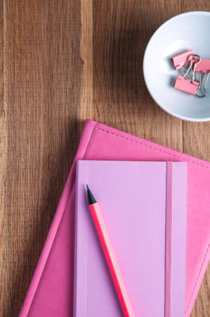 Pink notebooks and stationery on the tableの写真素材
