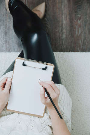 A woman holding a clipboard in her hands. Template for text or design. Top viewの写真素材