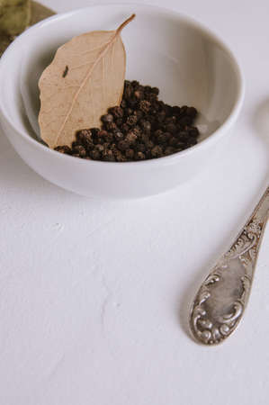 Black Pepper in white Cup on light background