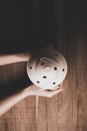 Woman holding a Christmas lantern on a wooden backgroundの写真素材