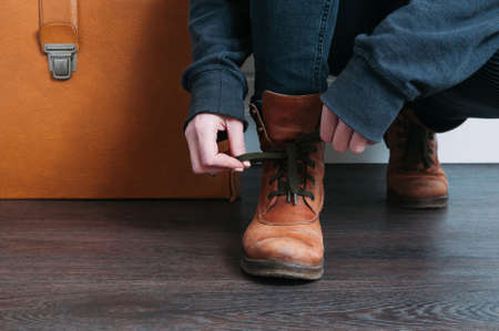 Female legs shod in Hiking boots and an old suitcase. Travel conceptの写真素材