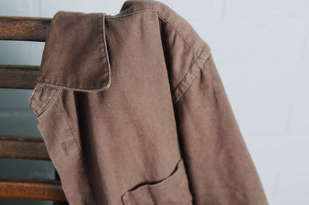 Brown men's shirt hanging on old chair