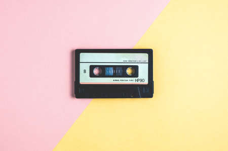 Old audio cassette tape on pink-yellow  backgroundの写真素材