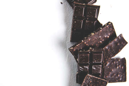 Pieces of dark chocolate on a light background