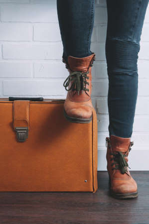 Female legs shod in Hiking boots and an old suitcase. Travel conceptの写真素材