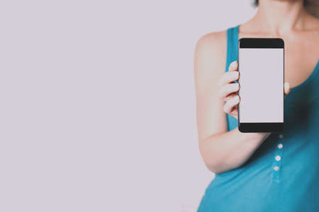 A woman holding a smartphone in her hands. Template for design or appの写真素材
