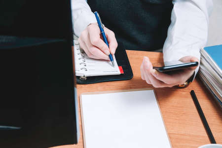 Business woman writes in a notebook. The concept of office work