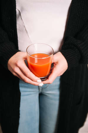 A woman holds a glass of vegetable juice in her hand. Diet or weight loss conceptの写真素材