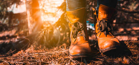 Female legs shod in Hiking boots on the forest background. Travel conceptの写真素材