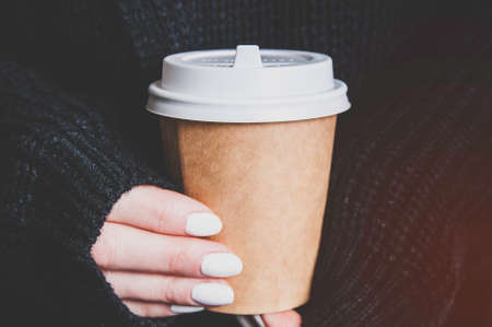 Woman holding a paper cup in her hands