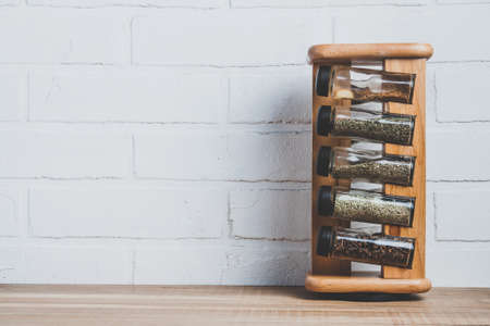 Colorful spices in jars on a brick wall background