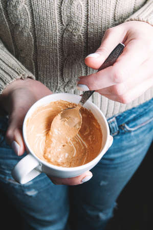 Woman holding a Cup of sweet sauce in her hands