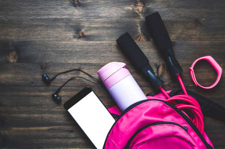Pink backpack with sportswear and a jump rope. The concept of fitness or runningの写真素材