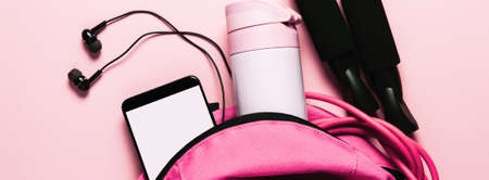 Sports bag and accessories on pink background