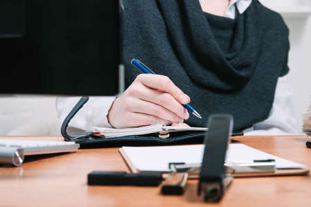 Business woman writes in a notebook. The concept of office workの写真素材