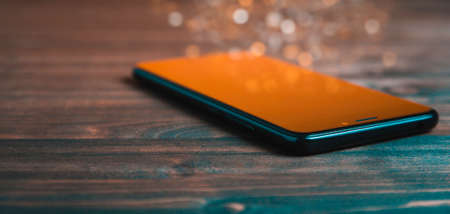 Black smartphone on wooden background. Copy spase for texy or designの写真素材