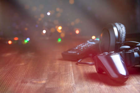 Game joystick and TV remote on a dark wooden background. Copy space for text or designの写真素材