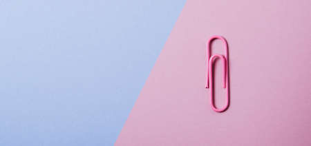 Pink paper clip on pink background