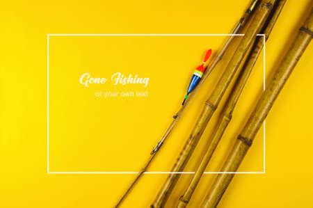 Old bamboo fishing rod on yellow backgroundの写真素材