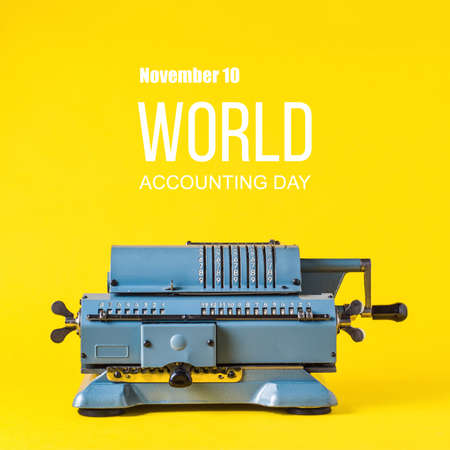 Old calculating machine on yellow background. Word Accounting day  conceptの写真素材