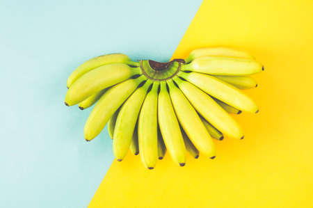 Banana isolated on turquoise-yellow background. Flat lay and top viewの写真素材