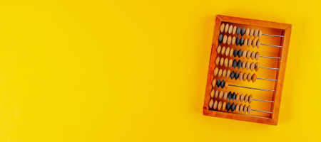 Old wooden abacus isolated on yellow background